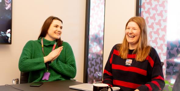 Two women in meeting room laughing