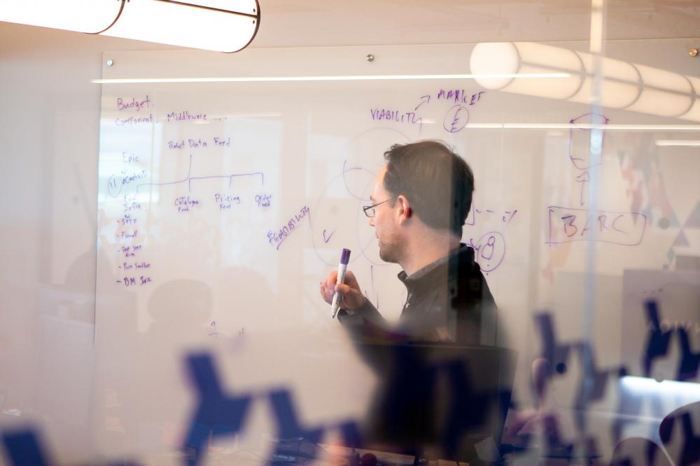 Consultant writing on a whiteboard