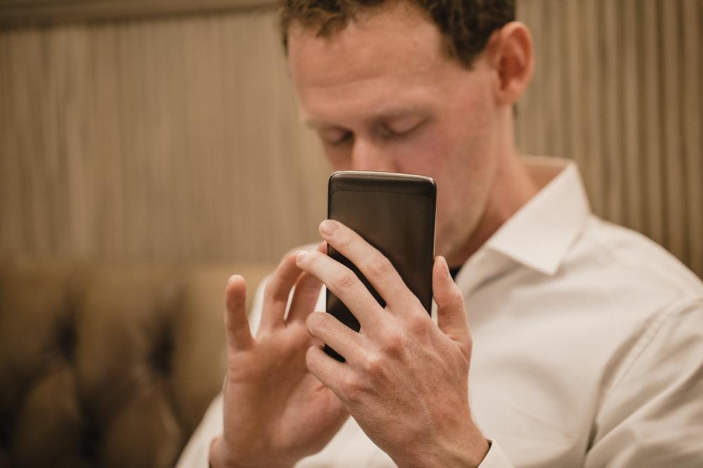 Blinder Mann sieht auf sein Handy