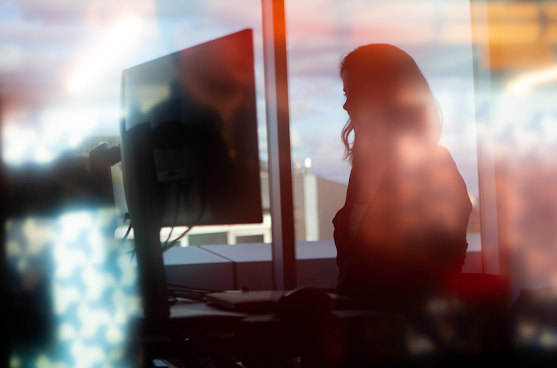 verschwommenes Bild einer Frau vor einem Computer
