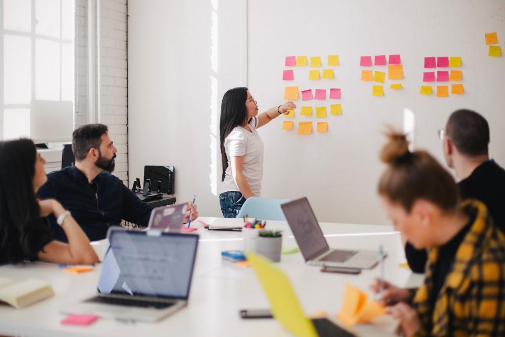 Menschen diskutieren am Whiteboard mit Post Its über die Customer Experience