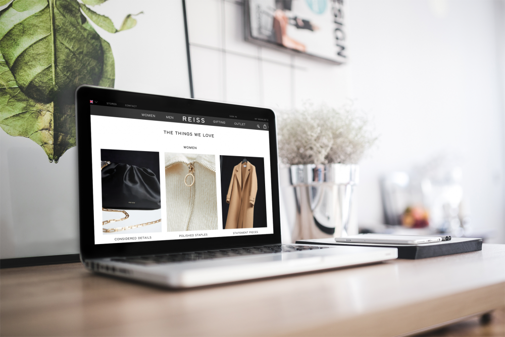 Laptop open with screen displaying REISS website
