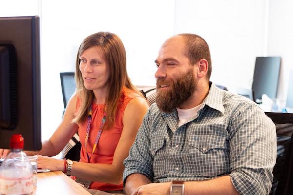 Female and male sitting in front of a desktop