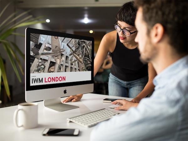 Man and woman looking at IWM website on Mac