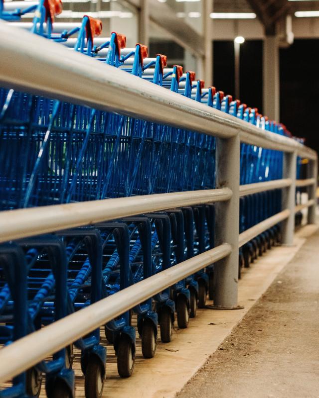supermarket shopping trolleys lined up in their bay outside a grocery store
